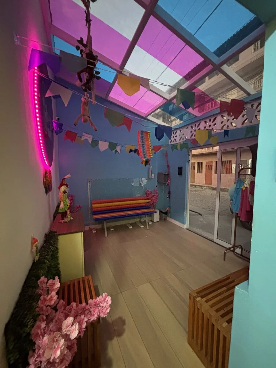 Área de acolhimento da Le Petit com bancos, bandeirinhas e cobertura colorida